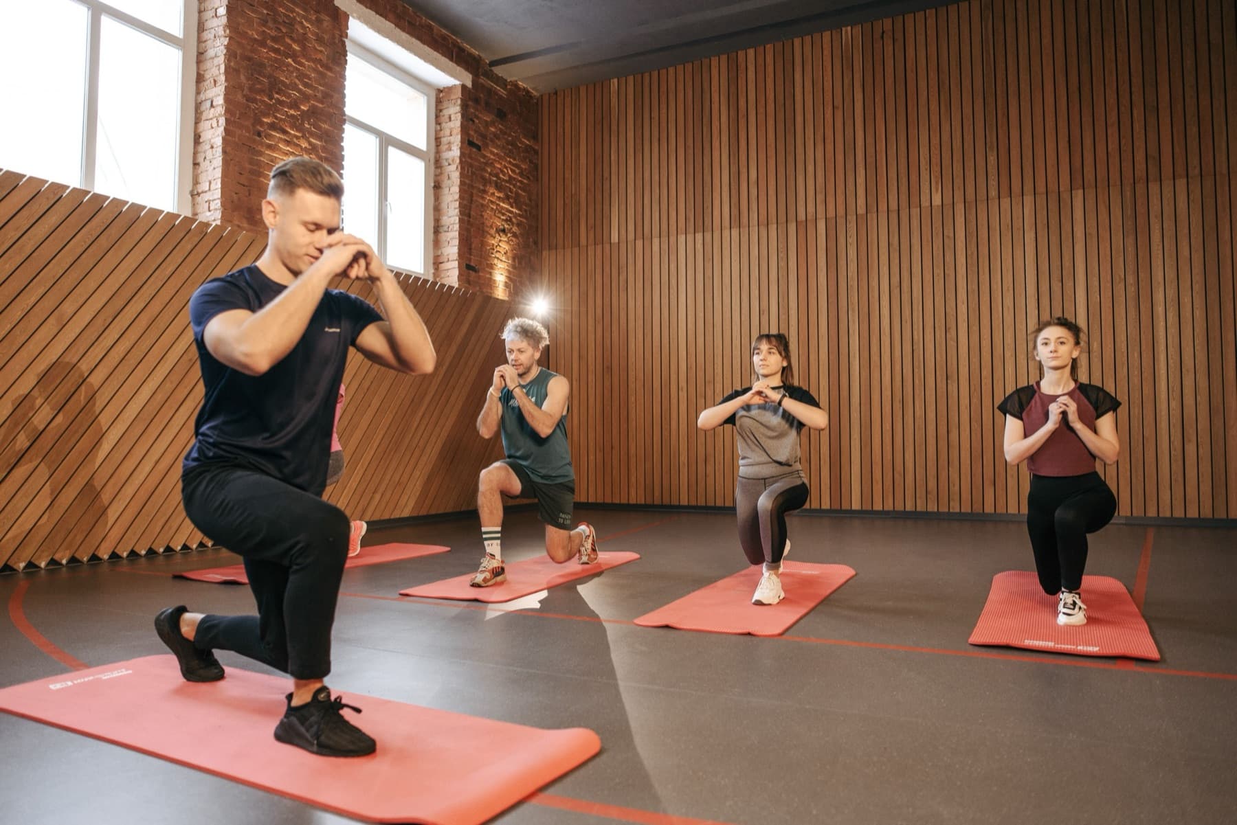 A group class mid-lunge on mats at a fitness studio