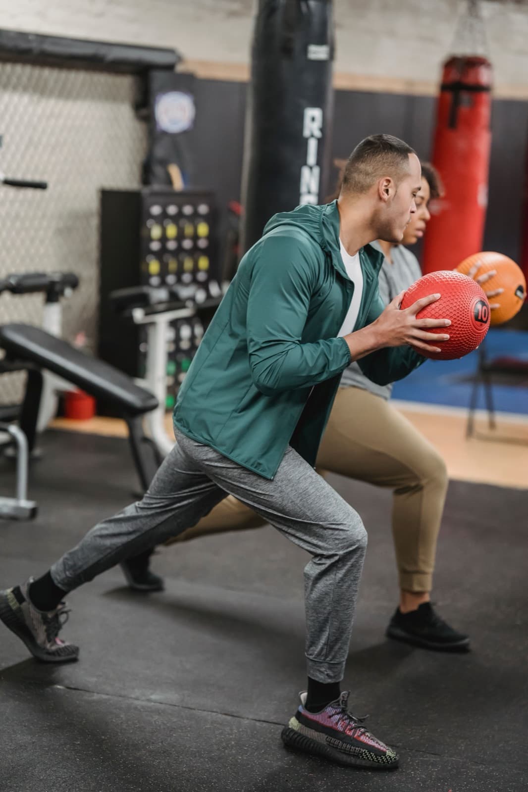 Two people training with medicine balls in a gym